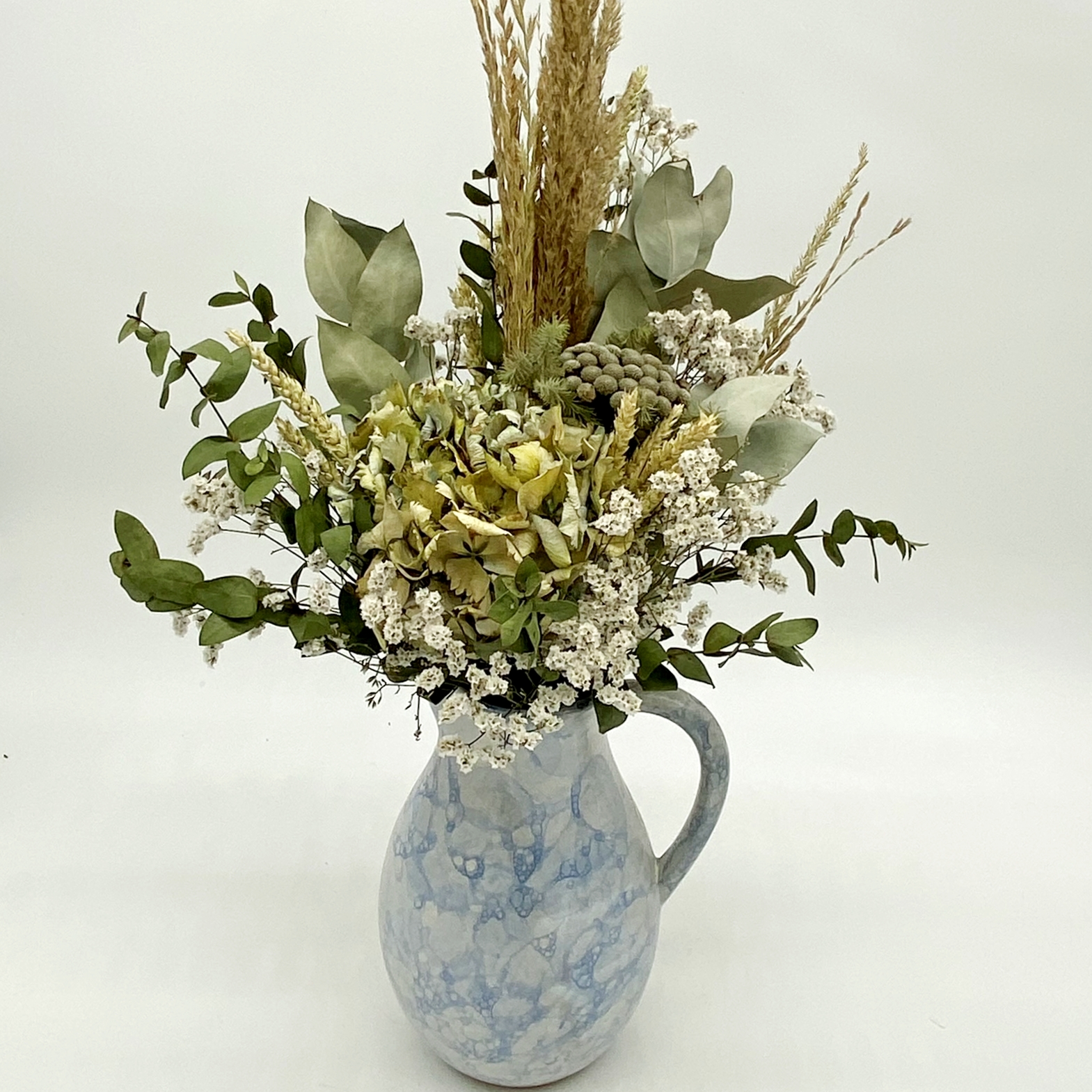 Arranjo de flores secas com jarro de cerâmica